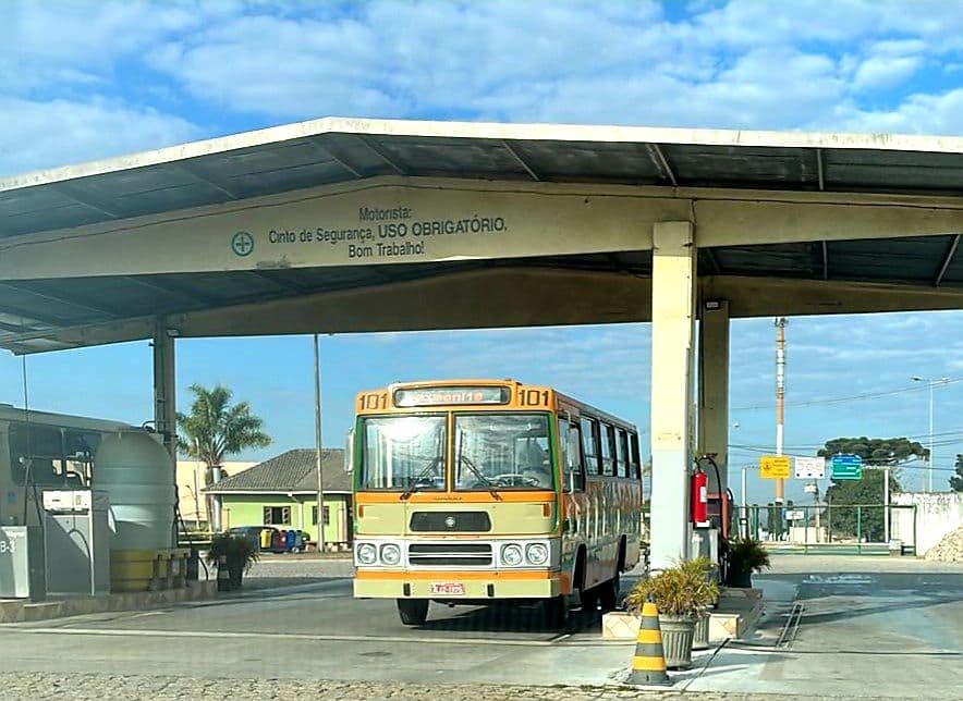 Ônibus clássico 101 parado sob a cobertura do posto de abastecimento