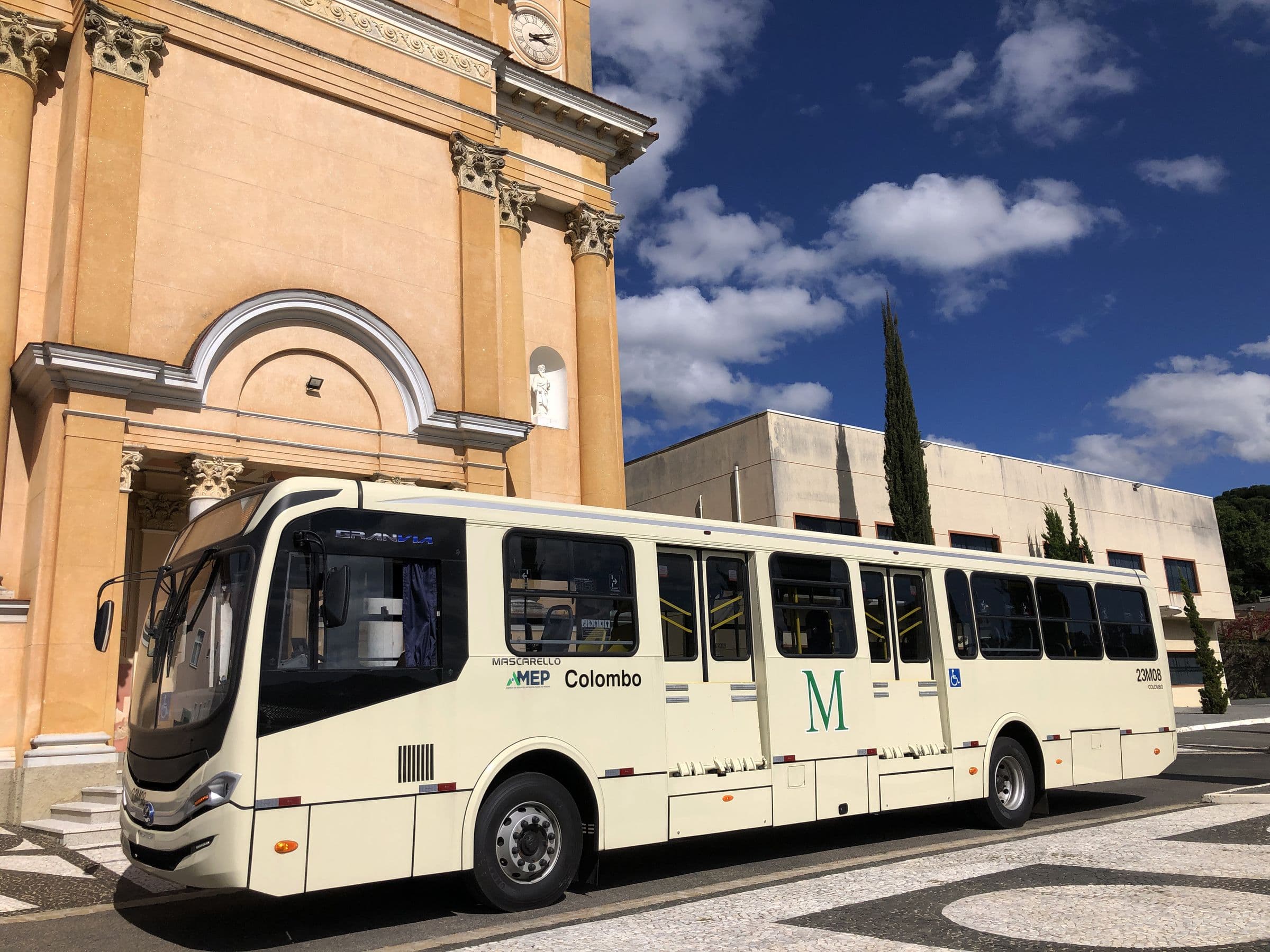 Ônibus metropolitano ao lado da fachada da Igreja Matriz de Colombo