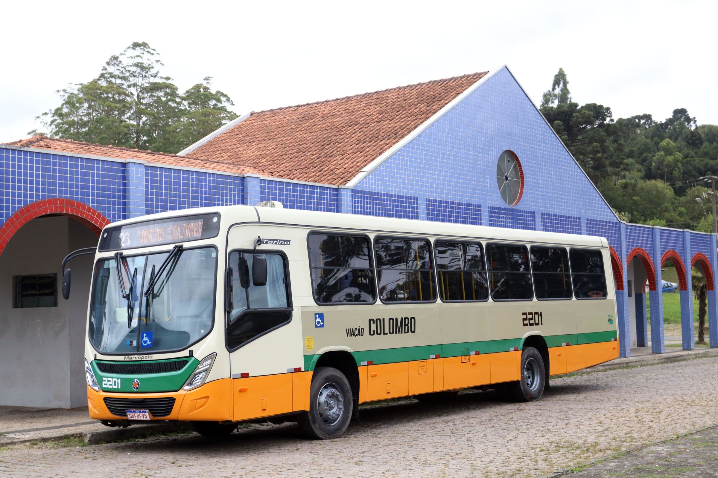 Ônibus da Viação Colombo em frente a um prédio de arcos