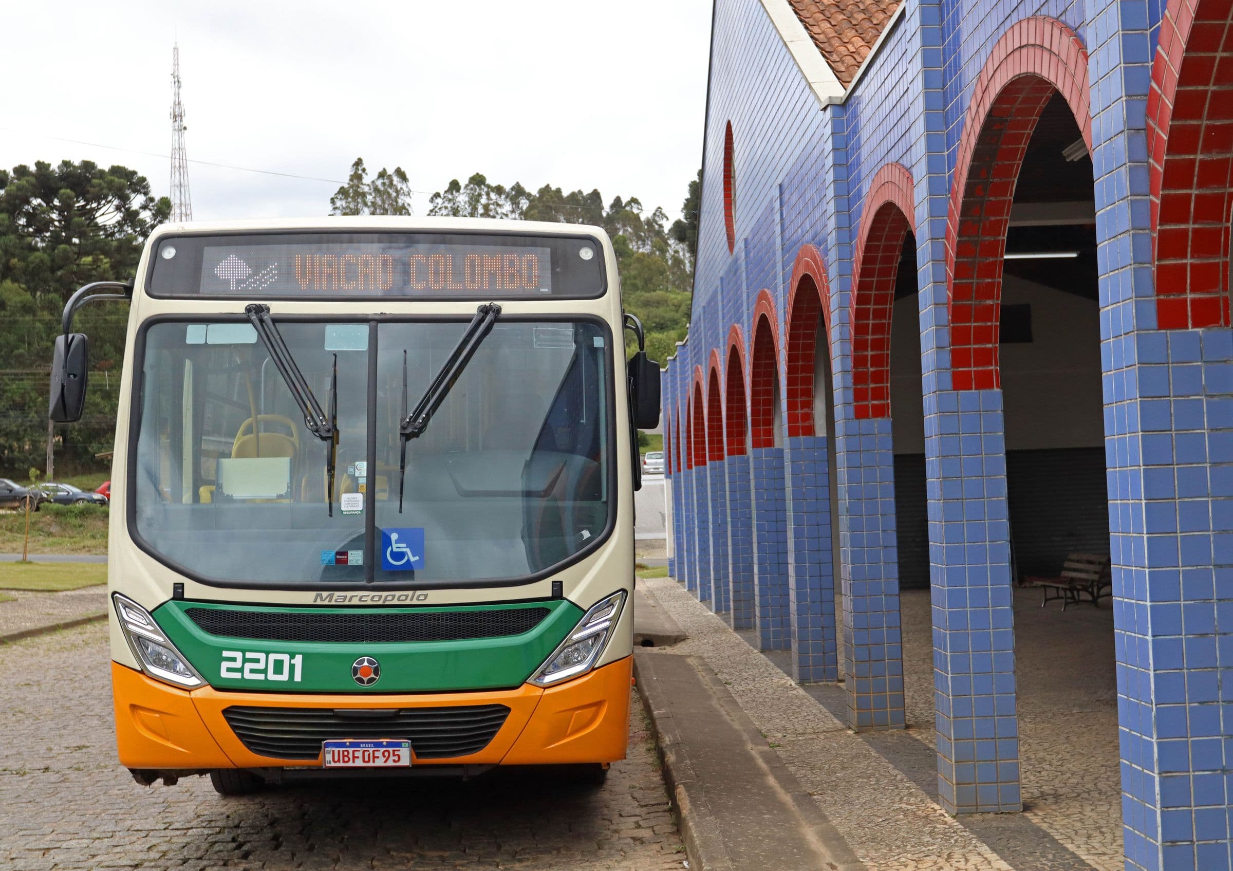 Ônibus 2201 de frente, ao lado de um prédio de arcos